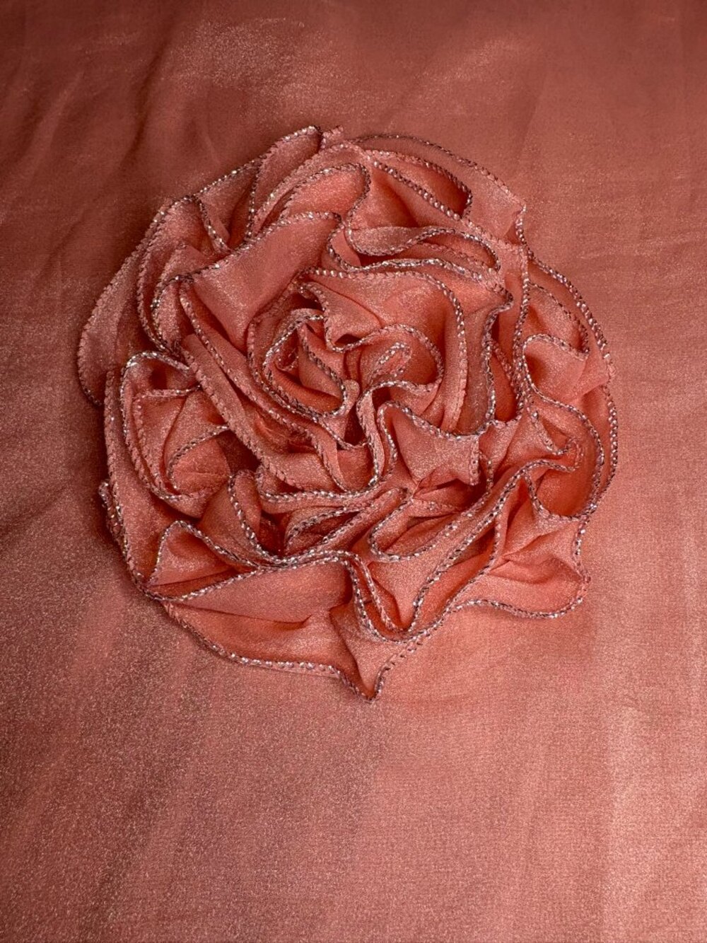 Iridescent peach colored scarf with silver trim and a 3 dimensional rosette